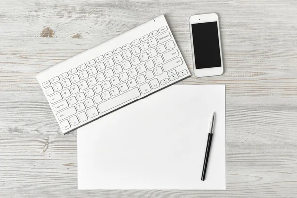 Pracoviště sady Office s klávesnicí, perem, bílým prázdným papírem a smartphone — Stock fotografie