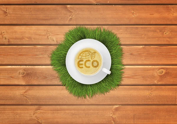 Xícara de café cappuccino com imagem símbolo ECO na superfície de madeira . — Fotografia de Stock