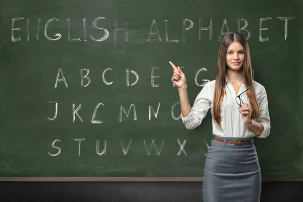 Attraktive junge Lehrerin in einem Klassenzimmer — Stockfoto