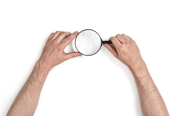 Руки человека, держащего увеличительное стекло на белом фоне — стоковое фото