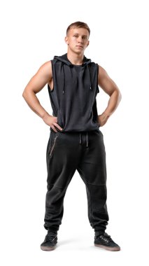 Kalça üzerinde elleriyle kaslı genç adam tam uzunlukta portresi