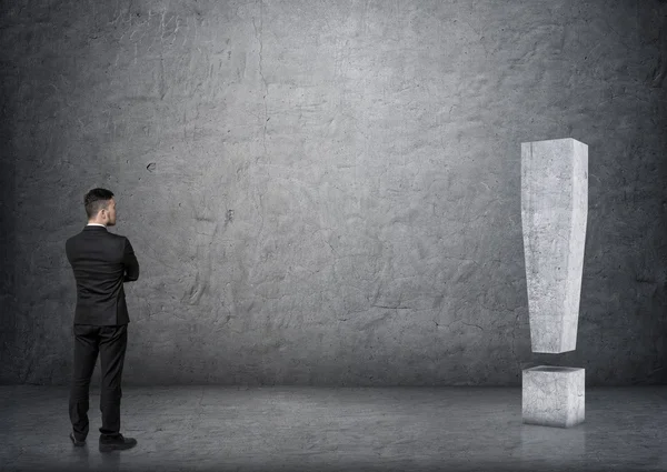 Задний вид бизнесмена касающийся большого 3D бетонного восклицательного знака — стоковое фото