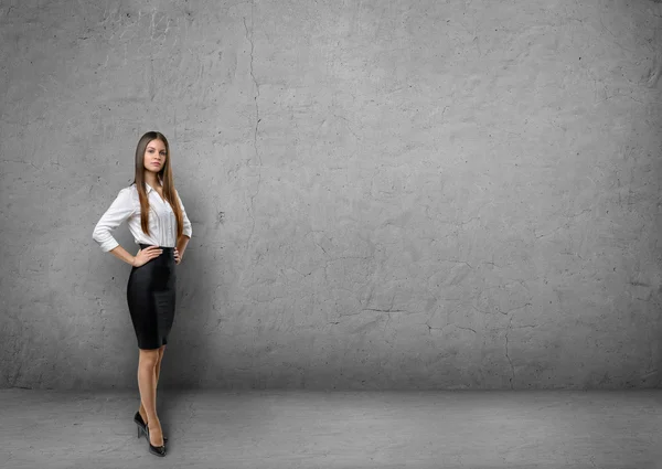 Jonge zakenvrouw hand in hand op haar taille in de achtergrond van de betonnen muur — Stockfoto