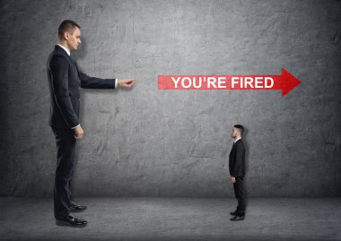 Big businessman poiting at red arrow with youre fired clipart
