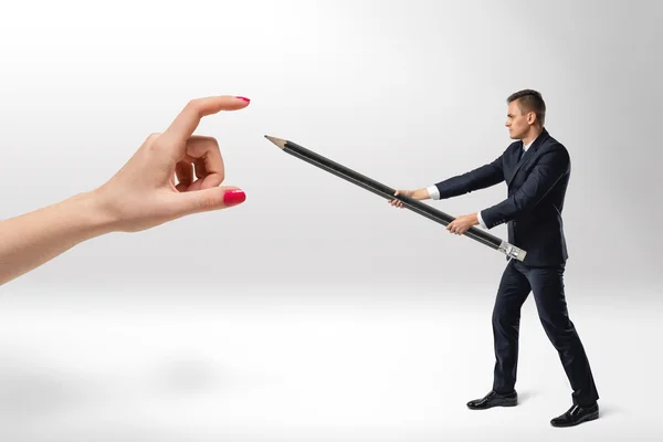 Zakenman verdedigt zich van dames hand met grote potlood — Stockfoto