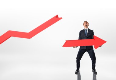 İki eliyle beyaz arka planda izole büyük kırık ok tutan işadamı