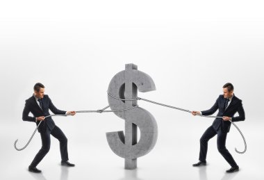 Beyaz arka planda izole zıt yönlerde halatlar ile büyük beton 3d dolar işareti çekerek iki işadamı