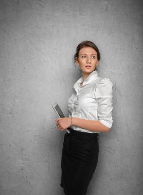 Beton duvara karşı ellerinde tablet ile güzel kız