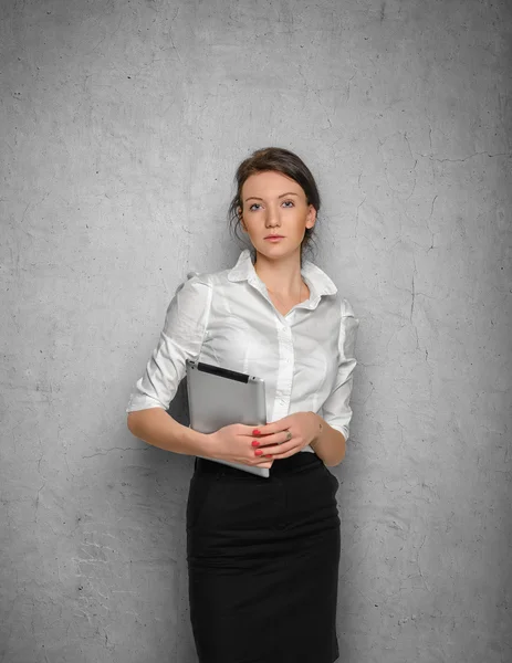 Beton duvara karşı ellerinde tablet ile güzel kız