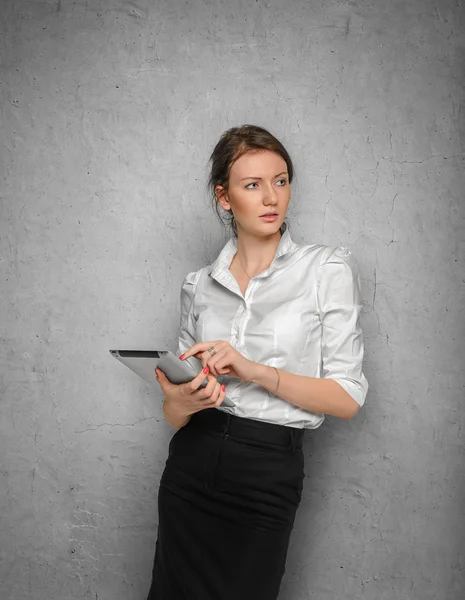 Mooi meisje met tablet in hun handen tegen de betonnen muren — Stockfoto