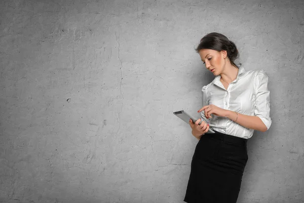 Meisje met Tablet PC te midden van betonnen wand — Stockfoto