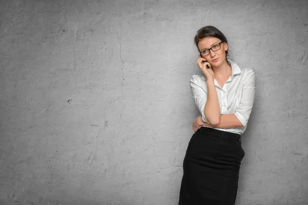 Meisje met telefoon temidden van betonnen wand — Stockfoto