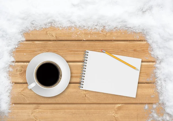 Koffie, potlood en notitieblok op de planken bedekt met sneeuw — Stockfoto