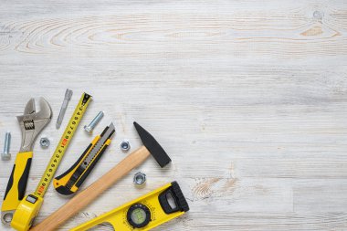 Ahşap DIY tezgah üzerinde üstten görünüm İnşaat aletleri ve araçları. Açık alan ile. Düzeyi, mezura, İngiliz anahtarı, çekiç, kesici.