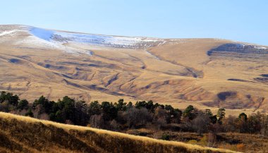 Kafkasya 'da dağları ve tepeleri olan güzel bir sonbahar manzarasının fotoğrafı.