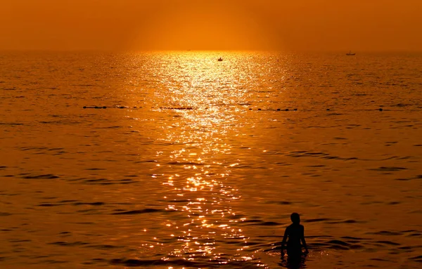 Photo of a sunset on the sea with a child in the evening. Example of a sunset on the sea for tourism