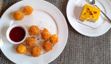 Bir yaz günü restoranda soslu peynir topları ve vejetaryen keki.