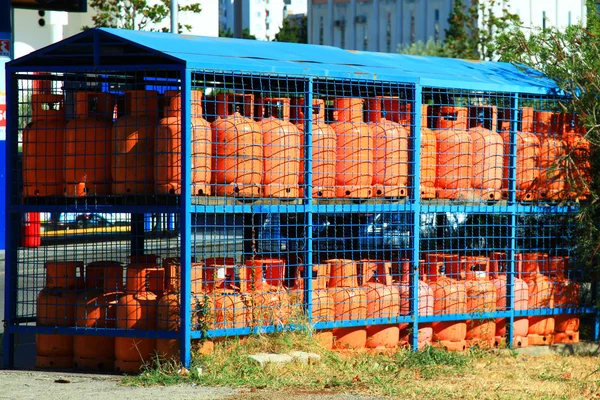 Σειρές από τα πολλαπλά δοχεία κόκκινο αερίων σε βενζινάδικο στην οδό Φωτογραφία Αρχείου