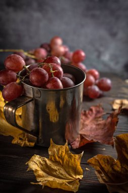Ahşap arka planda kırmızı üzümlerin durgun sonbaharı