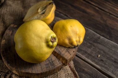 Kırsal ahşap arka planda taze sarı ayvalar