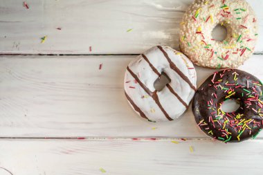 Ahşap bir arka planda çeşitli yeni pişmiş çörekler.