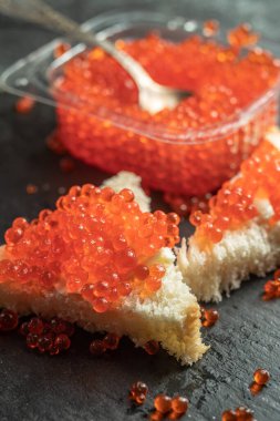 Kaşık üstünde taze kırmızı havyar ve bir parça ekmek