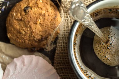 Ev yapımı zephyr, kurabiyeler ve ahşap bir arka planda bir fincan kahve.