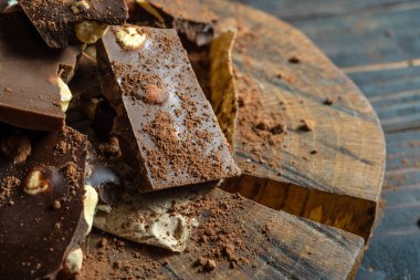 Kırsal ahşap arka planda pembe ve siyah çikolata parçaları