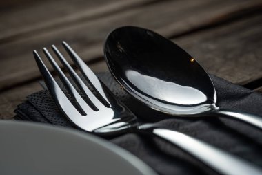 Ahşap bir restoranın arka planında çatal kaşık, paslanmaz çelik çatal bıçak.