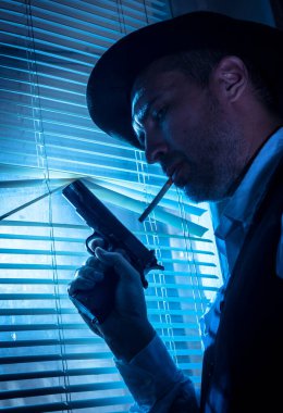 Pencerenin yanında sinema sahnesi olan şüpheli bir özel dedektif.