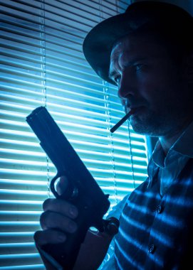 Pencerenin yanında sinema sahnesi olan şüpheli bir özel dedektif.