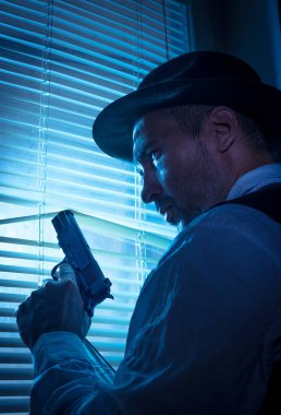 Pencerenin yanında sinema sahnesi olan şüpheli bir özel dedektif.