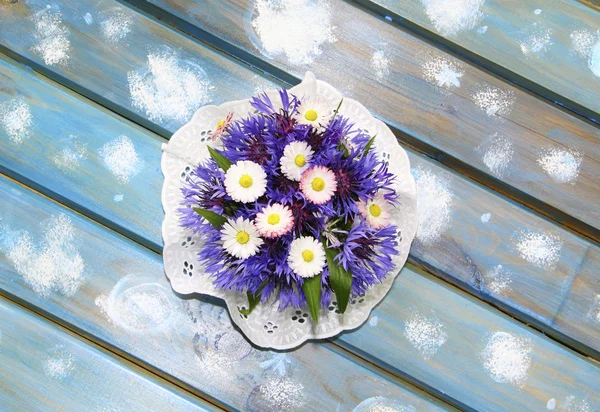 Adorável buquê de flores em uma mesa de madeira azul — Fotografia de Stock