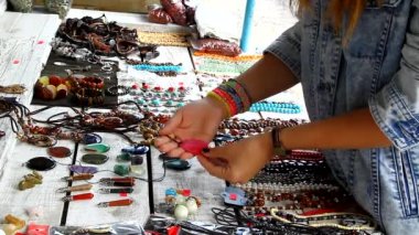 Genç bir kız içinde belgili tanımlık çarşı ve çalışırken boncuk ve kolye alır