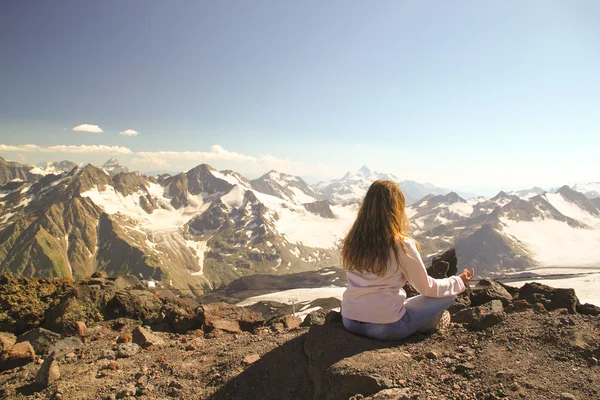 Doordachte meisje zit bovenop een berg tijdens een camping tr — Stockfoto