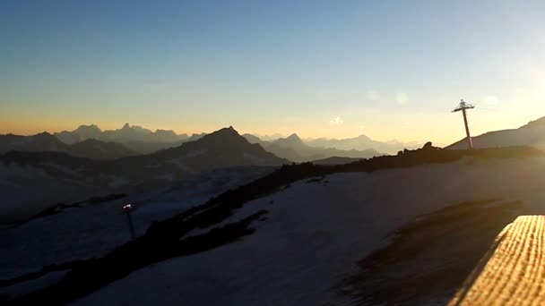 Les rayons obliques du soleil couchant sur une passerelle en bois au-dessus des sommets des montagnes — Video