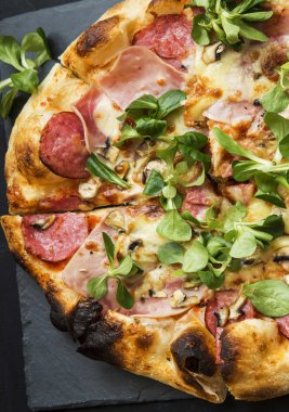 Pizza salam, peynir ve cornsalad yaprakları ile jambon