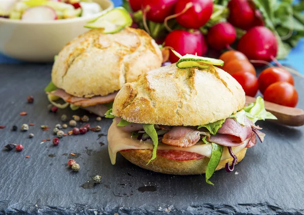 Sandwiches con tocino, queso, ensalada y pan rústico — Foto de Stock
