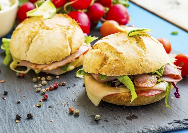 Sandwiches con tocino, queso, ensalada y pan rústico — Foto de Stock