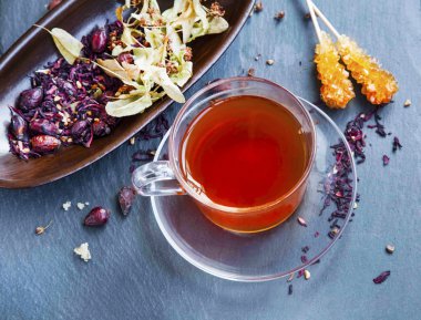 Ebegümeci ve kuşburnu kırmızı çay bardağı kuru çay yaprakları ve meyve