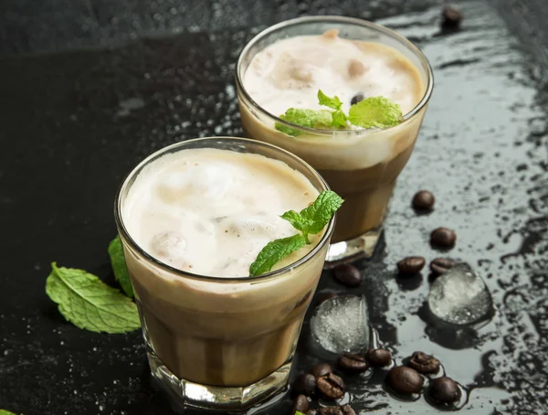 Холодный кофе в стаканах со льдом и свежими листьями мяты — стоковое фото