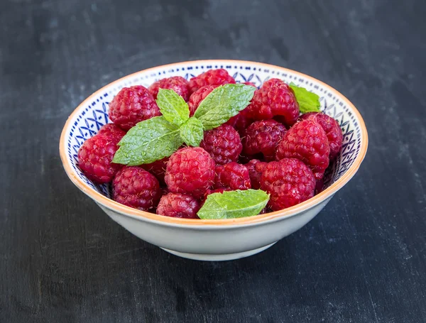 Fresh ripe raspberries in a bowl with mint — Stock Photo, Image