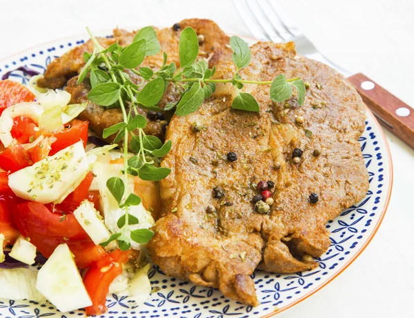 Filete de cerdo asado con especias y ensalada de verduras en plato rústico —  Fotos de Stock
