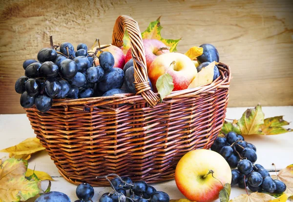 Frutas de otoño ecológicas en cesta con hojas secas — Foto de Stock