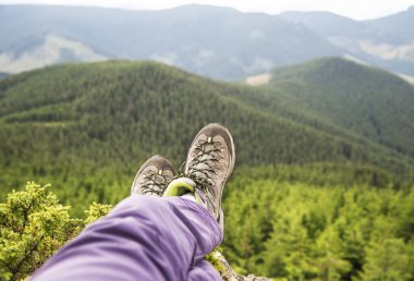 Dağ tepe rahatlatıcı üzerinde uzun yürüyüşe çıkan kimse bacaklar ve bot görünümü