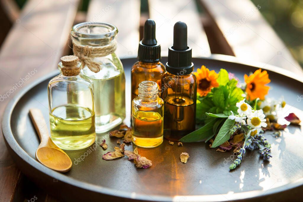 Alternative medicine, healing herbs oils, herbal aromatherapy oils with medicinal plants and herbs, essential oils bottles
