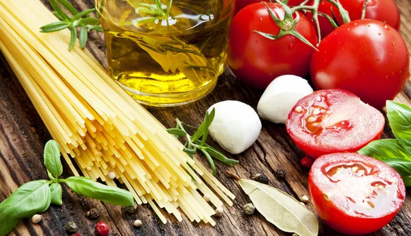 Ingredientes italianos, espaguetis, aceite de oliva, especias, tomate de cereza — Foto de Stock