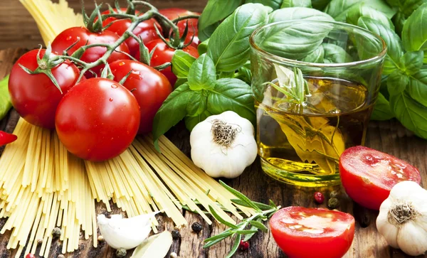 Włoski gotowania składników, spaghetti, tomates, oliwy z oliwek i bas — Zdjęcie stockowe
