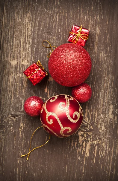 Rote Vintage-Weihnachtskugeln und Geschenke auf Holzgrund Stockbild