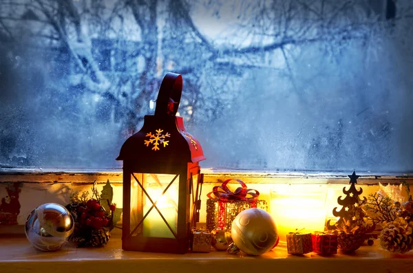 Linterna cálida en ventana congelada, magia de invierno con decora de Navidad — Foto de Stock